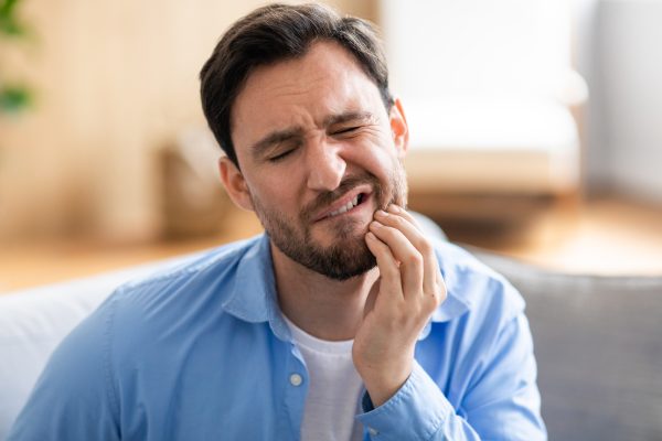 Stressed adult rubbing jaw with teeth grinding concept
