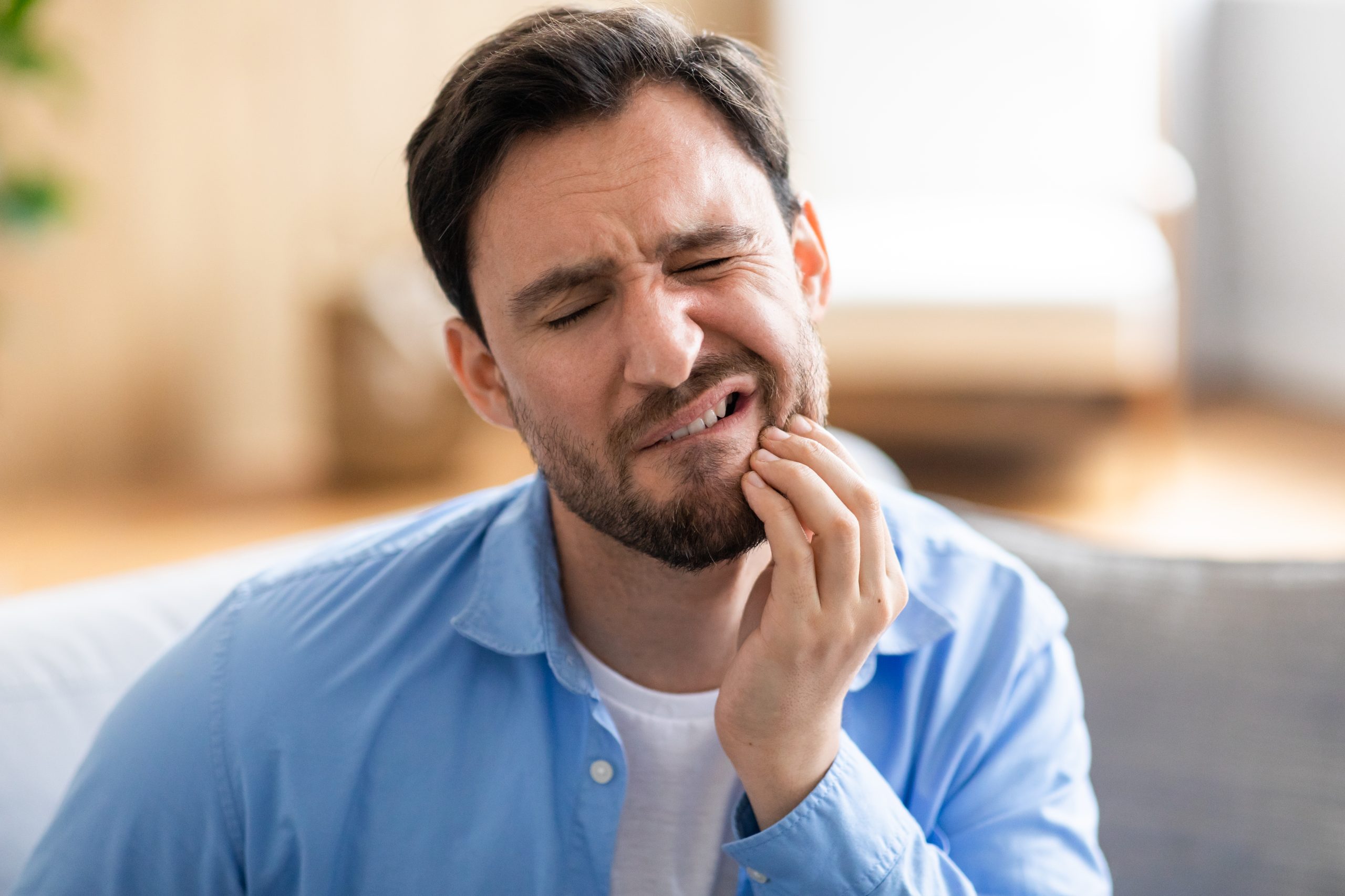 Stressed adult rubbing jaw with teeth grinding concept